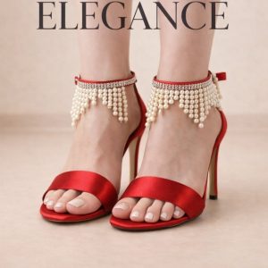 Üst Materyal: Göz alıcı ve parlak kırmızı saten kumaş. İnci Saçak Detayı: Bilek bandında kristal taşlarla zenginleştirilmiş, hareketli inci saçaklar. Topuk: 10 cm zarif yüksek topuk tasarımı. İşçilik: Dayanıklılık ve estetik için özel tekniklerle birleştirilmiş el işçiliği